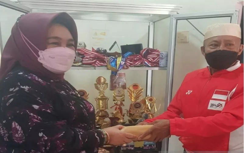 Anggota DPR RI Hj Tina Nur Alam menyerahkan hadiah uang tunai Rp100 juta yang diterima ayahanda Apriyani Rahayu, Amiruddin di Kabupaten Konawe, Sulawesi Tenggara, Selasa (3/8/2021). (Ant)