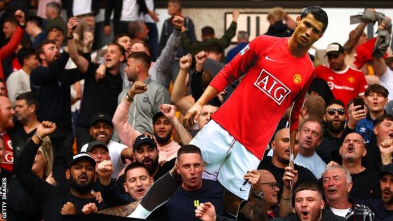 Penggemar Manchester United mengangkat tinggi-tinggi potongan karton Ronaldo di Wolves 