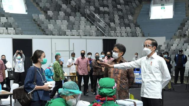 Presiden Jokowi berdialog dengan tenaga medis saat melakukan vaksin. (Ist).