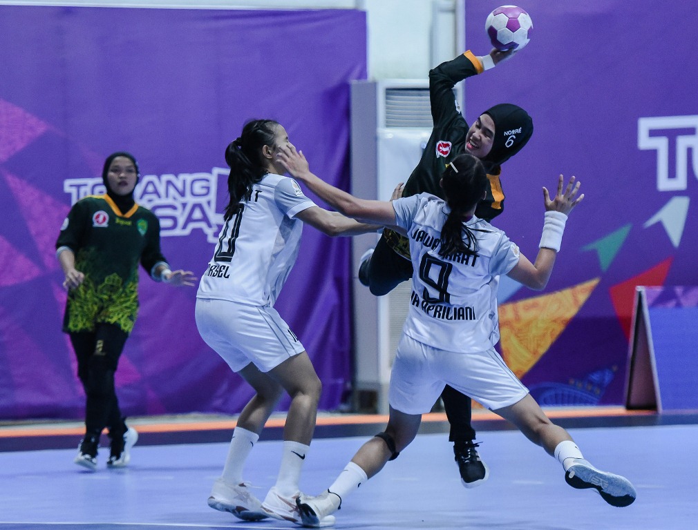Pemain bola tangan Kalimantan Timur Desi (hijau-6) dihadang dua pemain bola tangan Jawa Barat Lia Apriliani (putih-9) dan Marselina (putih-10) pada pertandingan final bola tangan putri PON XX Papua di Gor Futsal Mimika, Kamis (14/10/2021). PB PON XX Papua / Rommy Pujianto