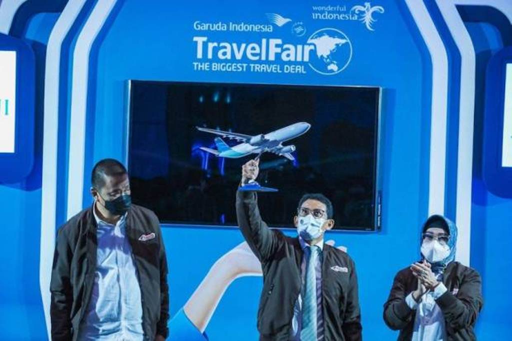 Menparekraf Sandiaga S Uno mengangkat miniatur pesawat Garuda Indonesia pada acara pembukaan Garuda Indonesia Travel Fair (GATF) 2021 di Jakarta, Jumat (10/12/2021).