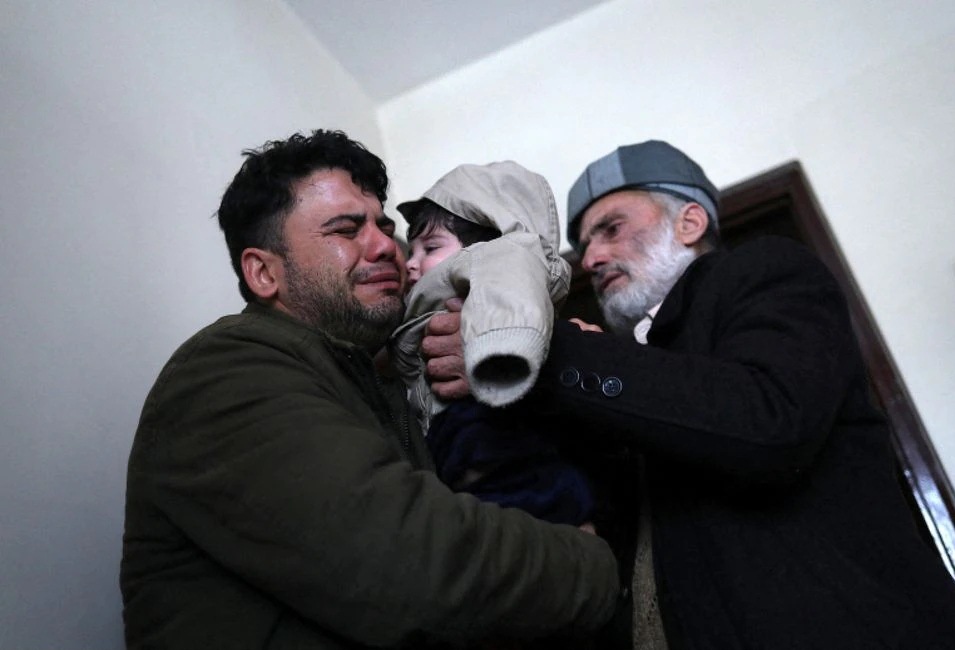 Hamid Safi, sopir taksi berusia 29 tahun yang menemukan bayi Sohail Ahmadi di bandara, menangis saat menyerahkan Sohail kepada kakeknya Mohammad Qasem Razawi di Kabul, Afghanistan, 8 Januari 2022