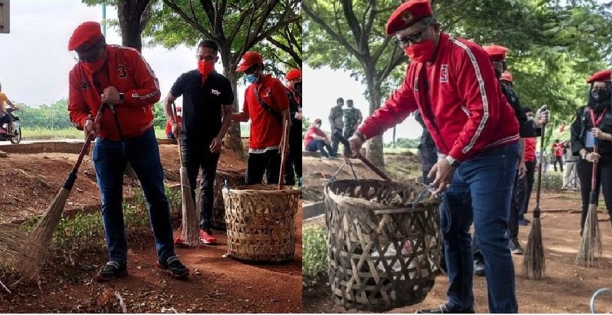 Sekjen Partai Demokrasi Indonesia Perjuangan (PDIP) Hasto Kristiyanto menyapu lalu mengangkat tempat sampah pada acara bersih-bersih lingkungan, penanaman dan pemelihara tanaman di Cakung, Jakarta, Minggu (9/1/2022). 