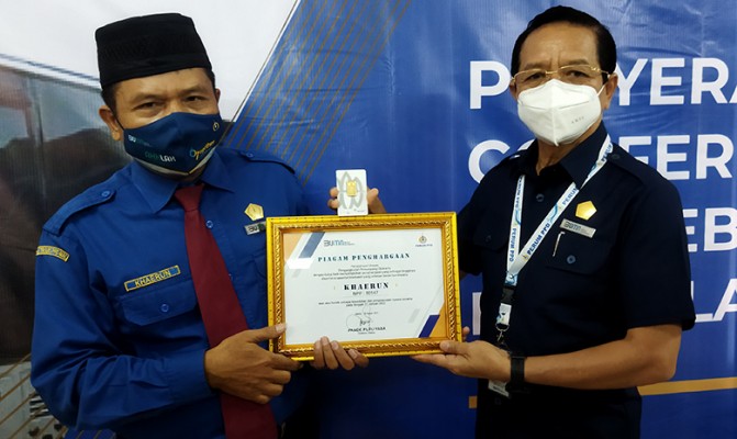Direktur Utama PPD Pande Putu Yasa (kanan) memberikan penghargaan kepada pengemudi bus di Kantor PPD, Klender, Jakarta, Jumat (28/1/2022).