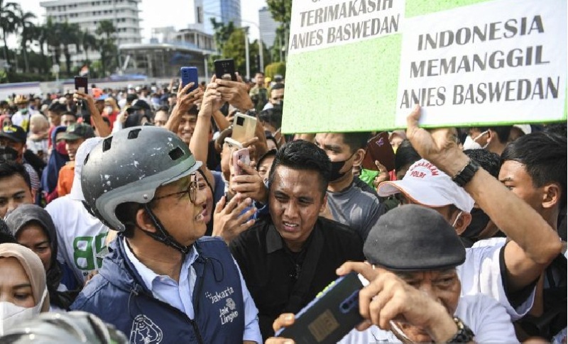 Gubernur DKI Jakarta Anies Baswedan (kiri) membaca poster Indonesia Memanggil yang dibawa oleh warga saat bersepeda pada Hari Bebas Kendaraan Bermotor (HBKB) di kawasan Bundaran Hotel Indonesia (HI), Jakarta, Minggu (16/10/2022). Kegiatan tersebut sebagai bentuk perpisahan dan berpamitan Anies Baswedan kepada warga Jakarta di hari terakhir menjabat sebagai Gubernur DKI Jakarta