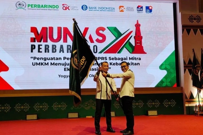 Ketua Umum Dewan Pengurus Pusat (DPP) Perhimpunan Bank Perkreditan Rakyat Indonesia (Perbarindo) periode 2018 - 2022 Joko Suyanto (kiri) secara simbolis menyerahkan kepemimpinan kepada Ketua Umum Perbarindo periode 2022 - 2026 Tedy Alamsyah (kanan) setelah terpilih secara aklamasi dalam Munas XI di Yogyakarta pada 20 Oktober 2022