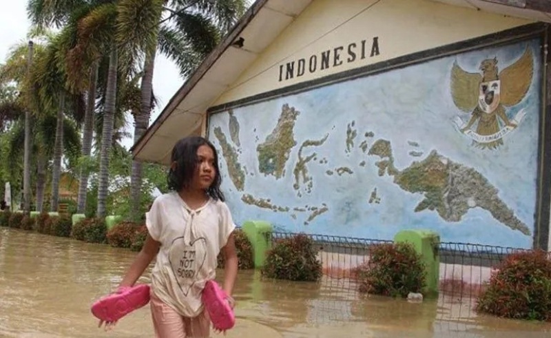 Seorang anak berjalan menerobos genangan air di depan sekolah yang terendam banjir di Kuala Simpang, Kabupaten Aceh Tamiang, Selasa (1/11/2022). (Ant) 
