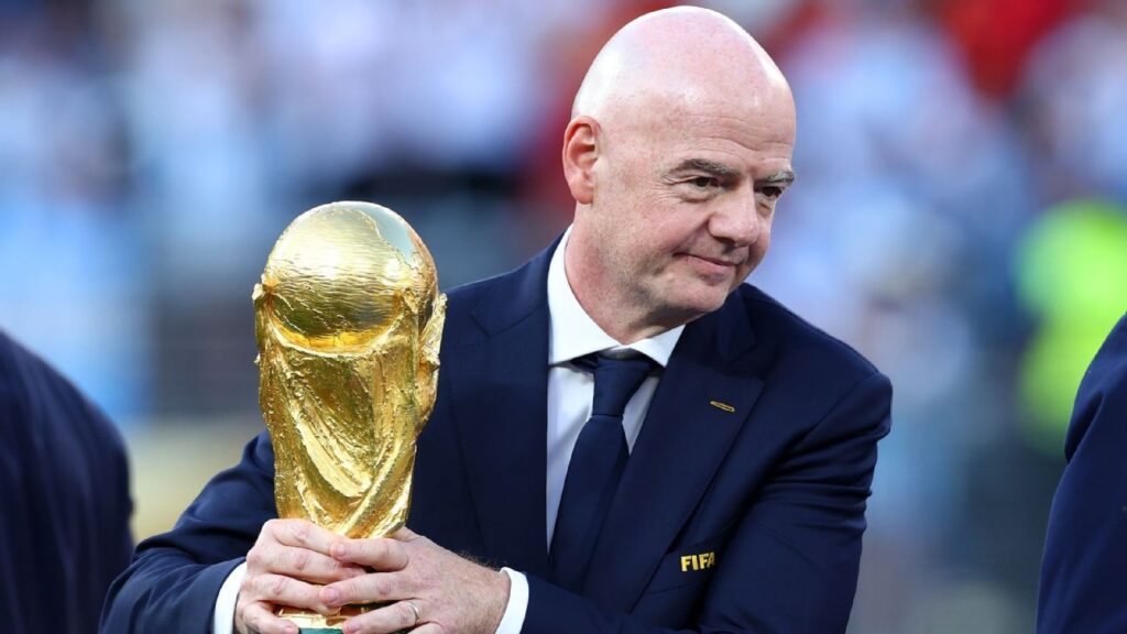 Presiden FIFA Gianni Infantino memegang tropi Piala Dunia yang mau dibisniskan dengan pikiran hanya cari cuan